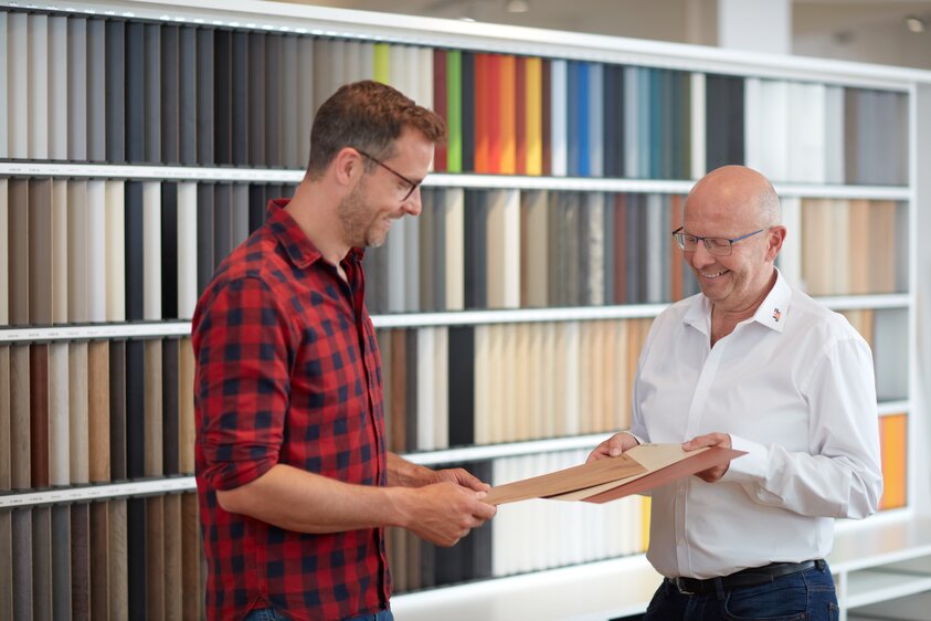 Mitarbeiter im Verkauf zeigt einem Kunden verschiedene Muster